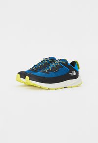 Chaussures de trail de course bleu et noir avec tige en maille texturée, accents jaunes et semelle extérieure en caoutchouc noir durable. Comprend des lacets réfléchissants.