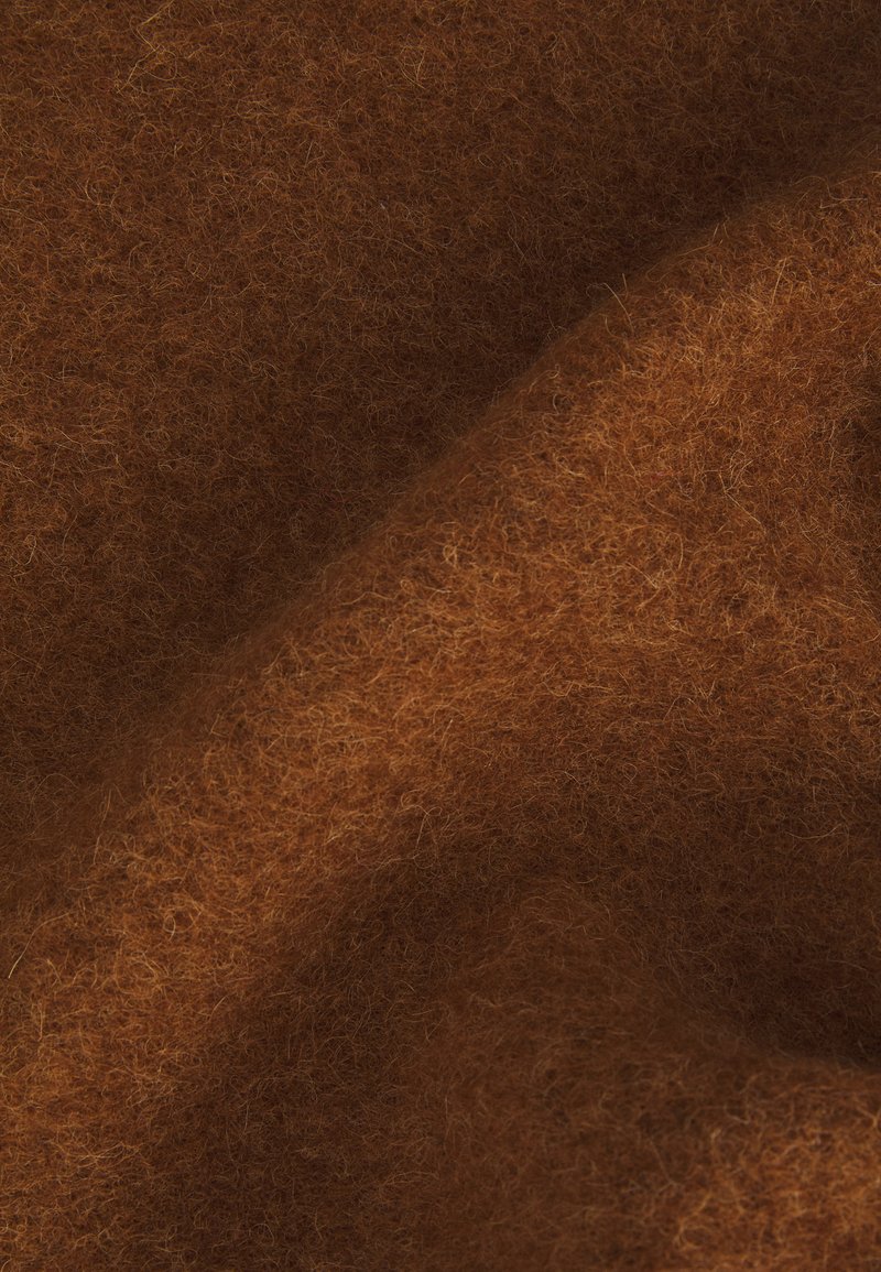 Bruin viltmateriaal met een zachte, gestructureerde oppervlakte, met fijne vezels en een gelijkmatige, viltachtige uitstraling in een rijke, warme tint.