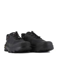 Black outdoor shoes with a rubber sole, featuring a textured upper, lace fastening, and reinforced toe for durability.