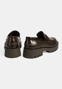 Bruine krokodillenembossed leren schoenen met een dikke, gestructureerde zool en een instapontwerp, met een lage vamp en een ronde punt.