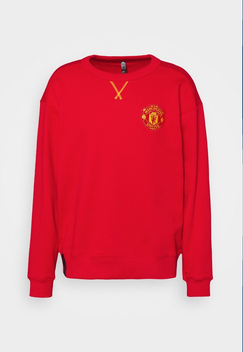 Sweat-shirt rouge à manches longues avec le logo de Manchester United sur la poitrine et un détail cousu jaune sous l'encolure.