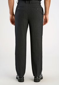 Grå ullbyxor med rak ben-design, med två bakfickor och en mjuk textur. Bärs med svarta skor, sedd bakifrån.