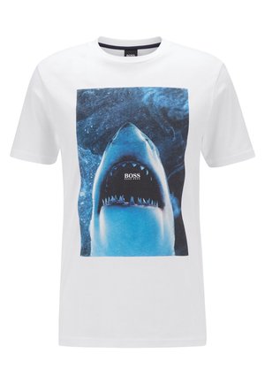 T-shirt blanc à manches courtes avec un grand graphisme d'un requin nageant vers le haut, la bouche ouverte, affichant le logo BOSS à l'intérieur de la bouche.