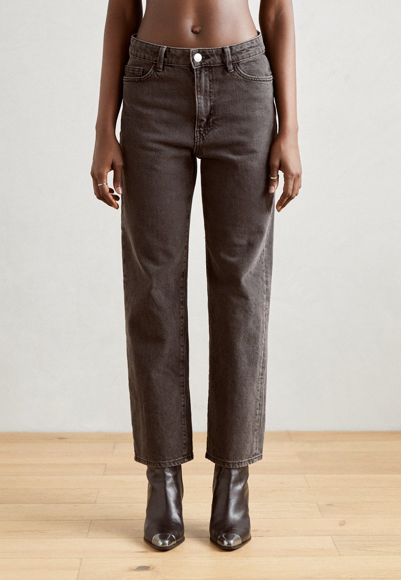 Jeans de tiro alto y pierna recta en denim gris oscuro con un diseño clásico de cinco bolsillos y cierre de botón metálico. Textura suave.