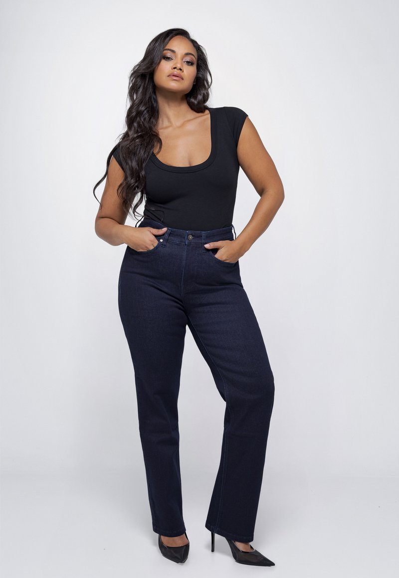Zwarte scoop-neck bodysuit gecombineerd met high-waisted donkerblauwe jeans. De jeans hebben een klassieke rechte pasvorm en zijzakken.