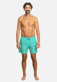 Bañador turquesa con un estampado floral; tejido ligero; cintura elástica con cordón ajustable; estilo casual hasta la rodilla.