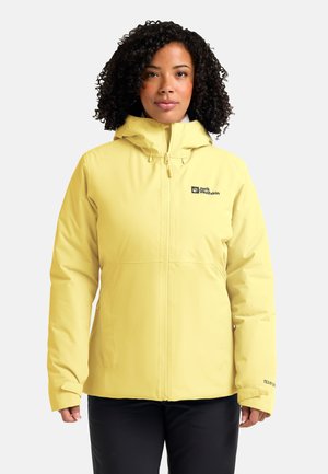 Veste imperméable jaune clair avec capuche ajustée, fermeture éclair avant et détail de logo. Fabriquée en matériau lisse et texturé, conçue pour une utilisation en extérieur.