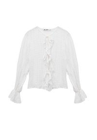 Weiße Bluse mit langen Ärmeln aus strukturiertem Stoff, mit einem zentralen Rüschendetail und ausgestellten Manschetten. Mit Bindeband am Ausschnitt.
