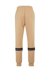 Beige sweatpants med en elastisk talje og marineblå striber ved manchetterne, der har en blød tekstur og en tapered bendesign.