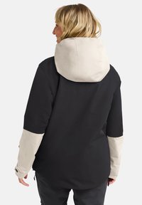 Giacca impermeabile nera e beige con cappuccio, caratterizzata da una texture opaca, maniche a contrasto e polsini regolabili. Vista posteriore mostrata.