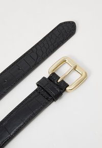 Cintura in pelle nera con stampa effetto coccodrillo, dotata di una fibbia rettangolare in metallo color oro e fori regolabili per la chiusura. Texture liscia su tutta la superficie.