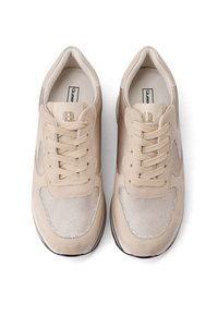 Sneaker beige in suede e mesh con lacci, suole imbottite e logo sulla linguetta, viste dall'alto su uno sfondo bianco.