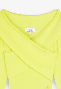 Lindgrüner Pullover mit einem breiten, umgeschlagenen Kragen und einer mit Perlen verzierten Ausschnittkante; aus speziellem Garn gefertigt, das Etikett zeigt Marke und Pflegehinweise.
