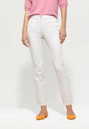 White slim-fit jeans made from cotton blend fabric, featuring front pockets and a button closure, paired with bright orange shoes.