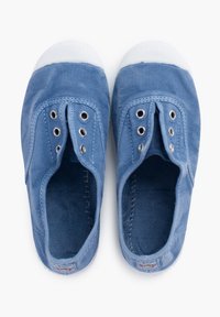 Baskets slip-on en toile bleue avec embouts en caoutchouc blanc, œillets pour lacets et doublure intérieure texturée. Semelle plate, design minimaliste.