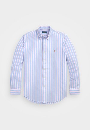 Chemise bleu clair à boutons avec des rayures verticales roses, col, manches longues, et un petit logo brodé sur la poitrine. Tissu en coton.