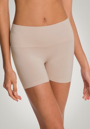 Lyhyet beige puristushousut, jotka on valmistettu joustavasta materiaalista. Niissä on leveä, sileä vyötärönauha ja ne ulottuvat reiden puoliväliin. Ei näkyviä saumoja tai kuvioita.