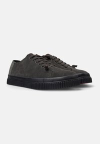 Ciemnoszare zamszowe sneakersy z czarną gumową podeszwą, okrągłym czubkiem i pasującymi sznurówkami. Charakteryzują się minimalistycznym designem i teksturowanymi detalami.