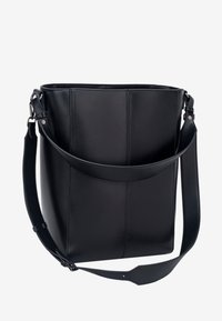 Sac seau en cuir noir avec une large bandoulière ajustable et un détail de couture verticale à l'avant sur fond blanc.