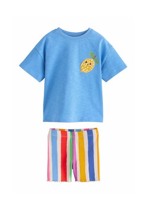 Chemise bleue à manches courtes avec un patch citron souriant, associée à un short rayé vertical multicolore avec une texture côtelée.