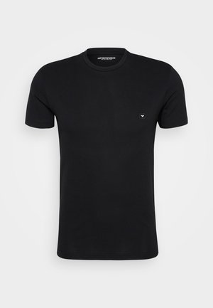 Μαύρο βαμβακερό μπλουζάκι με κοντά μανίκια και στρογγυλή λαιμόκοψη. Διαθέτει μια μικρή λογότυπη ετικέτα στο αριστερό στήθος. Απαλή υφή, μινιμαλιστικός σχεδιασμός.