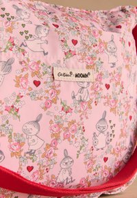 Pink fabric bag featuring Moomin character designs, floral patterns, and a red strap. Includes a label with "Cath Kidston x Moomin."