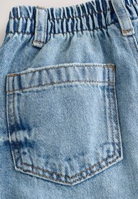 Hele sinised teksapüksid, millel on kummar elastne vöökoht ja üks tagatasku sirgjoonelise õmblusega ning õrn tekstuur.