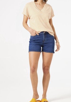 T-shirt a righe arancione e crema con scollatura a V abbinato a pantaloni shorts in denim blu, dal fit casual, orlo arrotolato e sandali gialli slip-on.