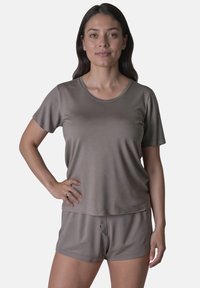 Top de color marrón claro, de manga corta y corte relajado, combinado con pantalones cortos a juego; confeccionado con una tela suave y lisa con un diseño simple.
