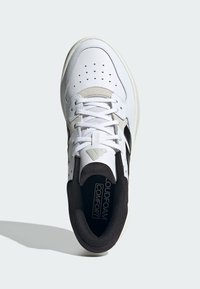 Sneaker bianco con punta perforata, accenti grigi e neri, lacci piatti e colletto imbottito. Presenta una soletta "LoudFoam Comfort".