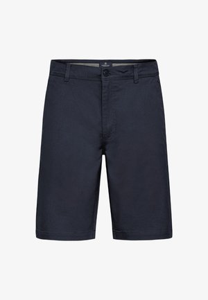 Tumedate sortsid, mis on valmistatud kergest kangast, lukuga ja nupuga sulgemisega, vöökoha silmadega ning puhaste, lihtsate joontega.