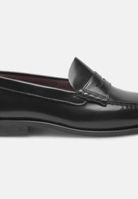 Mocassino in pelle nera con finitura liscia, caratterizzato da un accento intrecciato sulla parte anteriore. La scarpa ha un tacco leggermente sollevato e un design su misura.
