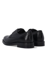 Schwarze Leder Schuhe mit glatter Oberfläche, runder Zehenform und klassischem Schnürdesign. Sie verfügen über einen niedrigen Absatz und nähtliche Akzente an den Seiten.