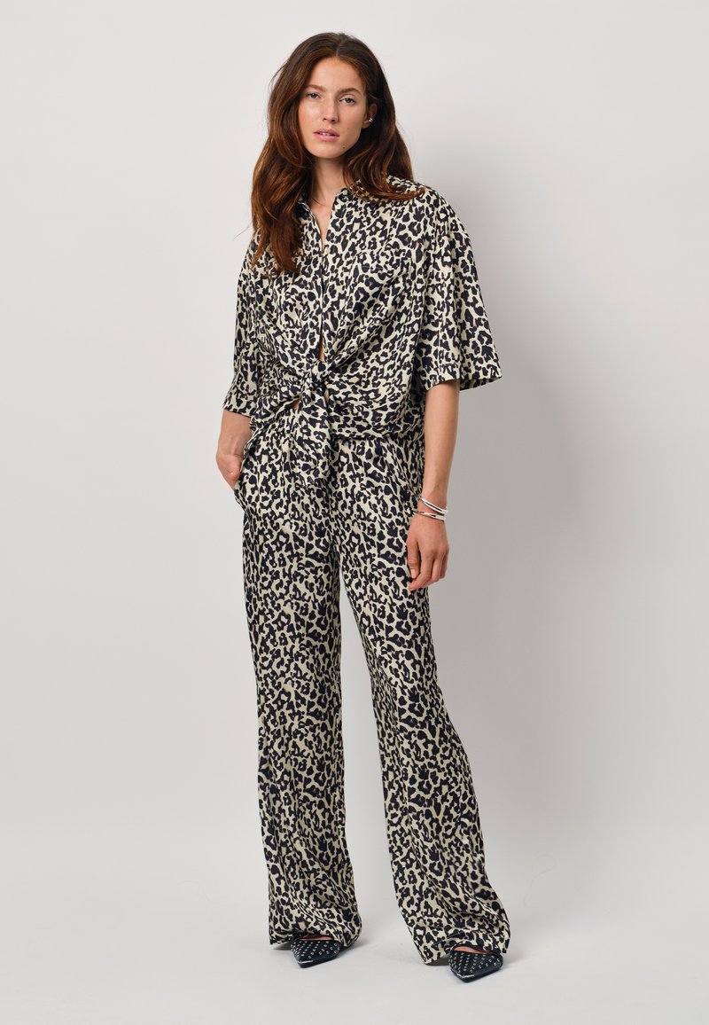 Leopard print co-ord set made of lightweight fabric; features a knotted short-sleeve top and wide-leg trousers with a flowing design.