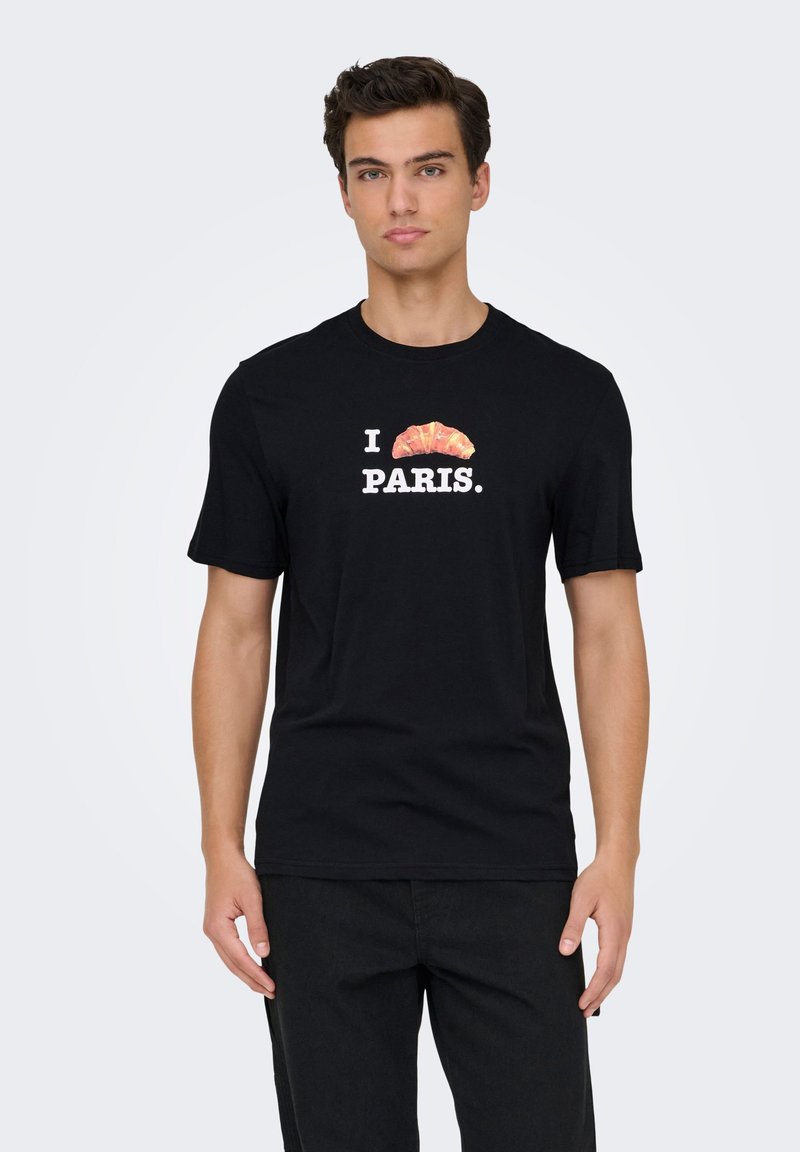 Μαύρο βαμβακερό μπλουζάκι με γραφικό τύπωμα κρουασάν πάνω από το κείμενο «I PARIS» σε λευκό. Κοντά μανίκια και στρογγυλή λαιμόκοψη.