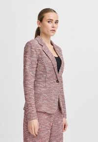 Maßgeschneiderter Blazer aus einem strukturierten Rot-Weißen Gewebe, mit Reverskragen, einfachem Knopfverschluss und Seitentaschen.