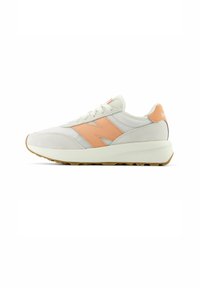 Sneakers leggeri in beige e arancione. Presentano una tomaia in rete con accenti in camoscio, una suola ammortizzata e un tacco rialzato. Design classico con lacci.