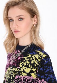 Maglione lavorato a maglia con base nera, caratterizzato da un motivo astratto multicolore nei toni del rosa, giallo e blu. Collana in argento e dettagli ad occhiello.