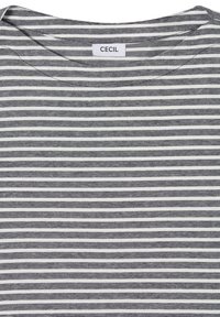 Chemise à rayures horizontales blanches et noires avec col rond et étiquette de marque "CECIL" cousue à l'arrière du col.