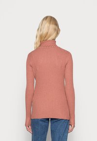 Pitkähihainen, ribattuja kauluspaitaa dusty rose -värissä, valmistettu pehmeästä neuloksesta, jossa on istuva siluetti ja hieman pidempi selkä.