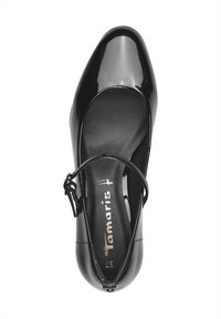 Svart lackläder pumpsko med rund tå, justerbar rem och en mjuk innerdel. Har en diskret logotyp på innersulan. Storlek 37.