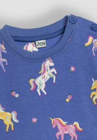 Lichtblauw kindertrui met kleurrijke eenhoorn- en bloemenpatronen, voorzien van een geribbelde halslijn en knoopdetails op één schouder.