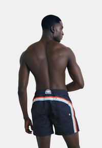 Costumi da bagno neri con strisce contrastanti arancioni e azzurre, una patch con logo sul retro e una cintura con cordoncino.