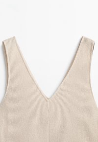 Beige gerippter Tanktop mit tiefem V-Ausschnitt und breiten Trägern. Der Stoff ist weich und dehnbar und weist ein dezentes vertikales Muster auf.