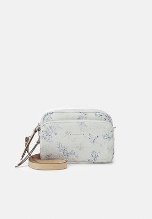 Sac bandoulière à motif floral en matériau blanc avec deux compartiments zippés et une bandoulière détachable beige. Présente une texture lisse et un design fonctionnel.
