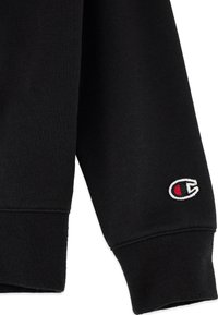 Sudadera negra con puños de canalé, que cuenta con un logo bordado en blanco y rojo. Fabricada con tejido texturizado y con un diseño clásico de cuello redondo.