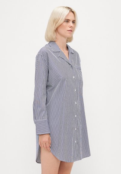 Vestido camisola riscado em azul marinho e branco, com fecho frontal em botões, mangas longas, gola e fendas laterais para facilitar o movimento.