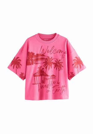 Chemise à manches courtes rose vif avec des graphismes rouges de palmiers et de cabanes et un texte indiquant "Welcome to Paradise on Earth" sur le devant et les manches.