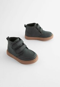 Scarpe alte nere con due fasce in Velcro, suole in gomma e una texture liscia. Presentano una punta arrotondata e una caviglia imbottita per il comfort.