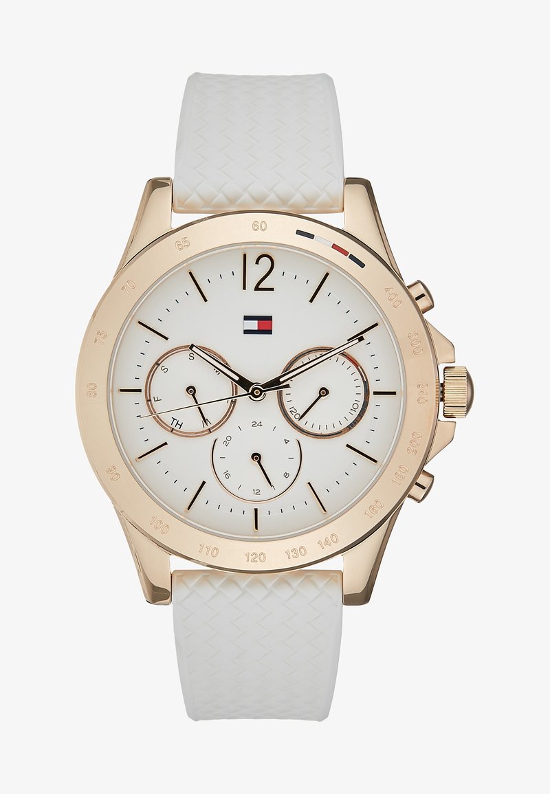 Montre-bracelet ton or avec bracelet blanc texturé, cadran blanc, trois souscadrans pour le jour, 24 heures et la date, aiguilles noires et dorées, et logo Tommy Hilfiger.